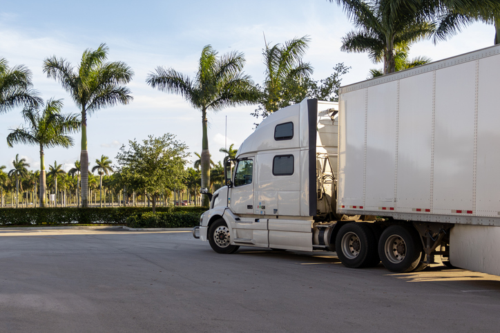 White truck with a white trailer parked on the side of the road in Florida - West Palm Beach truck accident lawyer