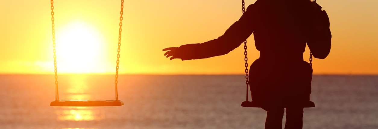 A bereft woman reaches for her missing loved one at sunset on the beach.