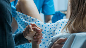 Woman holding her partner’s hand for support through childbirth and labor