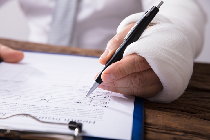 Injured man signing documents - Melbourne Personal Injury Lawyers