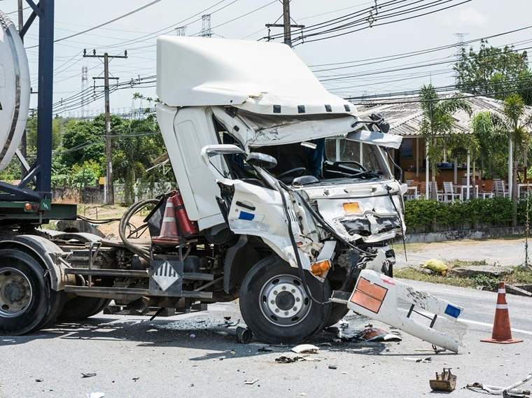 A truck full of chemicals in the middle of the road after a common type of truck accident.