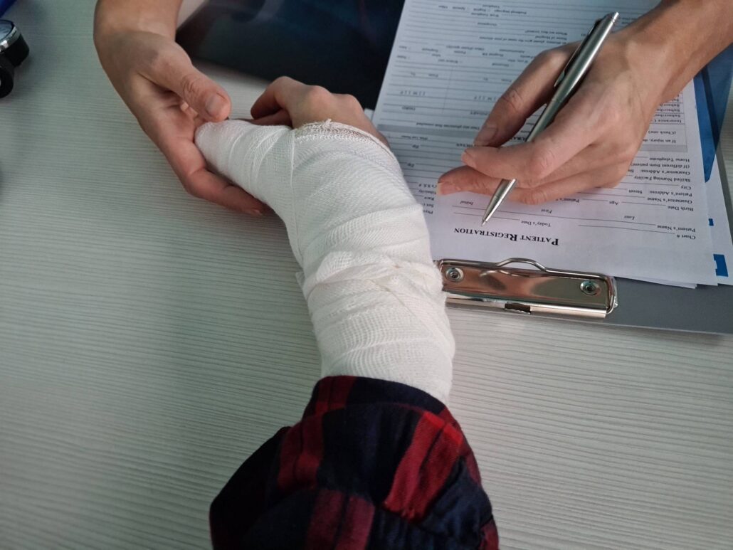 boca raton personal injury lawyer - Medical professional wrapping a patient injured hand while documenting care details in a clinic
