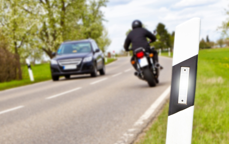 motorcycle passing car on the road - does a car accident affect motorcycle insurance