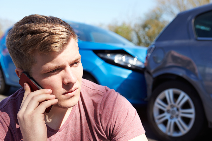 Man on phone after a car accident - Is it illegal to settle a car accident privately