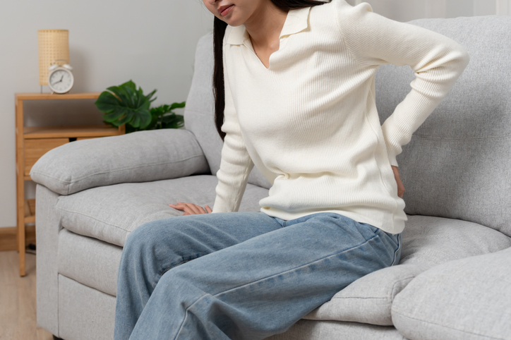 Woman in pain holding her lower back - Can a car accident aggravate scoliosis?