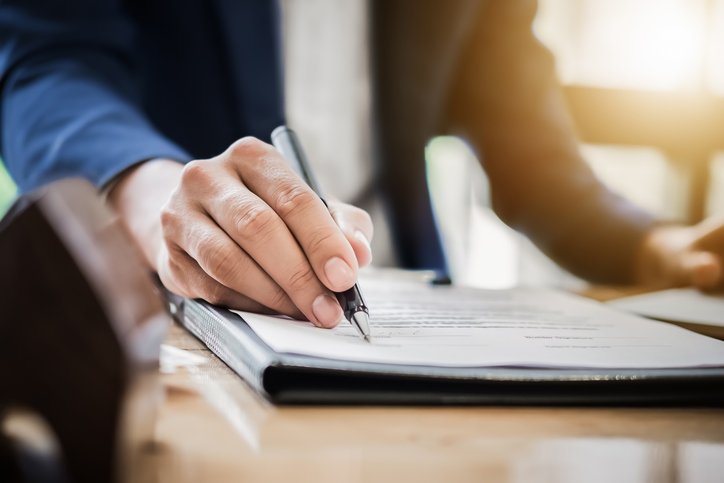 Person signing a document - How are expenses handled in personal injury legal fees?