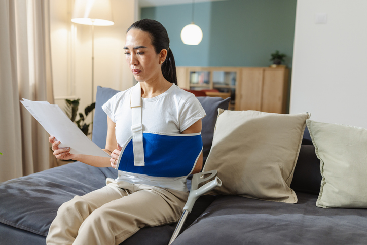 injured woman at home reading a document - A CEO's assistant suffers a personal injury at home—what are their rights?